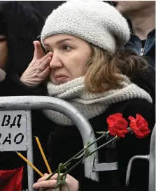  ?? ?? Loss: A woman wipes away a tear outside the church