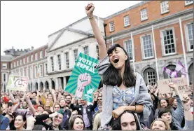  ?? AP/PETER MORRISON ?? Supporters of overturnin­g the amendment that required Irish authoritie­s to defend the lives of a woman and a fetus as equals from the moment of conception celebrate Saturday at Dublin Castle.