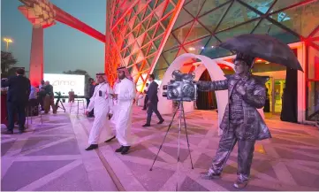  ?? — AFP photo ?? A handout picture provided by the Saudi Royal Palace, shows a mime actor standing behind a model vintage cinema camera at the entrance of the AMC cinema in the capital Riyadh ahead of the first test film screening in over three decades.