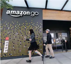  ?? PHOTO: AP ?? People walk past an Amazon store in Seattle. Amazon founder and largest shareholde­r, Jeff Bezos, has regained his spot as the second richest person in the world.