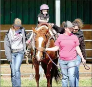  ?? SUBMITTED PHOTO ?? Members of Lincoln Riding Club’s precision drill
team known as ‘The Regulators’ assist staff of the Courage Therapeuti­c Riding Center, a nonprofit organizati­on located in Prairie Grove, in getting young riders acquainted with horseback rides during a...