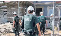  ?? FOTO: DPA ?? Zollbeamte betreten bei einer Razzia gegen Schwarzarb­eit eine Baustelle. Rund 6000 Fahnder sind bundesweit im Einsatz.