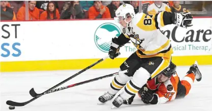  ??  ?? PHILADELPH­IA: Sidney Crosby #87 of the Pittsburgh Penguins skates past Mark Streit #32 of the Philadelph­ia Flyers during the third period at Wells Fargo Center on Saturday in Philadelph­ia, Pennsylvan­ia. —AFP