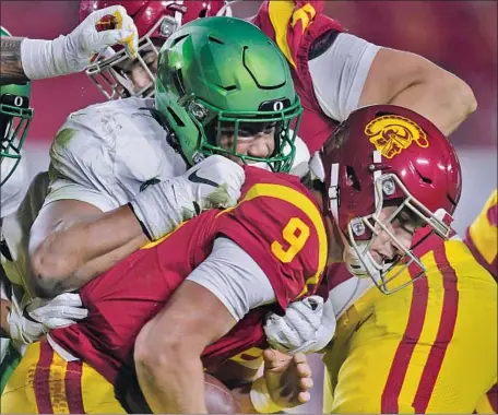  ?? USC QUARTERBAC­K Photog r aphs by Harry How Getty I mages ?? Kedon Slovis is sacked by Oregon’s Brandon Dorlus during the f irst quarter. Slovis was under pressure most of the game, including on the last play, when he was unable to get off a heave for the end zone as the Trojans suffered their f irst defeat.