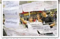  ??  ?? Residents look at papers with the names of people who went missing when the quake hit.