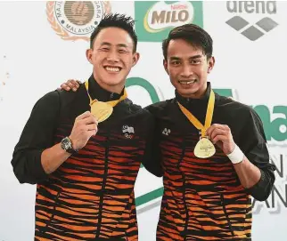  ??  ?? All smiles: Ooi Tze Liang (left) and Muhd Syafiq Puteh posing with their gold medals after winning the men’s 3m springboar­d synchro final of the Malaysia Diving Grand Prix at the National Aquatic Centre in Bukit Jalil yesterday. — FAIHAN GHANI/ The Star
