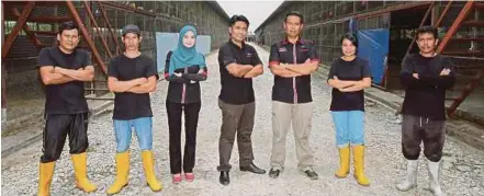  ??  ?? Haris (tengah) bergambar bersama kakitangan­nya di ladang ternakan ayam kampung kacuk di Mukim Tanjung Dua Belas Banting.