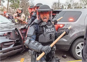  ?? KEREM YUCEL/AFP VIA GETTY IMAGES ?? Police officers clash with protesters late Sunday after an officer shot and killed Daunte Wright, 20, after a traffic stop in Brooklyn Center, Minn., not far from where former officer Derek Chauvin is being tried on murder charges in the death of George Floyd last summer.