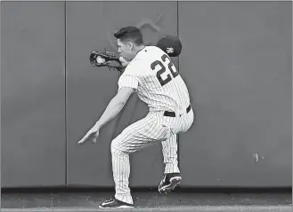  ?? KATHY WILLENS/AP PHOTO ?? Yankees center fielder Jacoby Ellsbury steadies himself after colliding with the outfield wall fielding a flyout by Alcides Escobar of the Royals in the first inning of Wednesday’s game at New York.