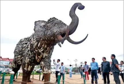  ?? HENG CHIVOAN ?? Envionment officials and journalist­s view an elephant statue made of chainsaws seized from timber traders and illegal loggers in Mondulkiri province on Monday.