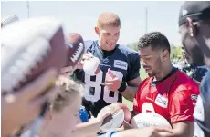  ?? STEPHEN BRASHEAR/THE ASSOCIATED PRESS ?? Seattle Seahawks quarterbac­k Russell Wilson, right, seen with tight end Jimmy Graham signing autographs, has signed a four-year contract extension with the team on Friday.