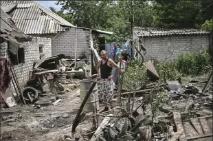  ?? ARIS MESSINIS/AFP VIA GETTY IMAGES ?? Maksym Katerin stands in the yard of his damaged home after his mother and stepfather were killed during shelling in the city of Lysychansk in the eastern Ukrainian region of Donbas on Monday.