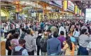  ?? PTI ?? Commuters wait at Chhatrapat­i Shivaji Maharaj Terminus after railway services were disrupted due to heavy rain, in Mumbai, on Monday