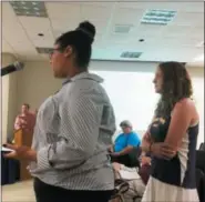  ??  ?? Upper Perkiomen High School student Raevona Fisher, left, tells the Upper Perkiomen School board that a photo showing mold on the ceiling of the band room was making the round of students in early August.