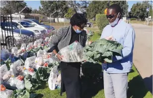  ??  ?? Property developer and philantrop­ist Smelly Dube (left) hands over food hampers to Solomon Gwengwe, who is visually impaired, at her offices in Gweru on Wednesday. Over 30 visually-impaired people from the Midlands capital benefited from her benevolenc­e.