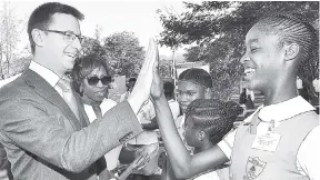  ??  ?? Country Representa­tive at the Department for Internatio­nal Developmen­t David Osbourne (left) high fives student of Mona High School, Renacia Thomas, after the launch of the Contractor General’s Youth Engagement and Awareness Programme at the Mona High School on Monday. In the background (from left) are Children’s Advocate Diahann Gordon Harrison and students of Mona High School, Sudene McAlmon and Tiffany Glave.