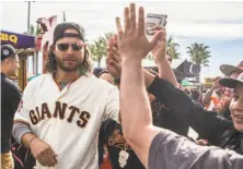  ?? Jessica Christian / The Chronicle 2018 ?? Giants shortstop Brandon Crawford high-fives fans during last year’s FanFest. Crawford is set to appear at Saturday’s event.