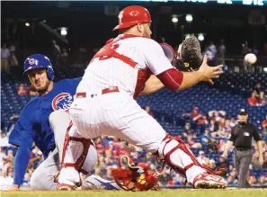  ?? (Reuters) ?? CHICAGO CUBS baserunner Kris Bryant (left) slides safely into home plate as Philadelph­ia Phillies catcher Cameron Rupp awaits the ball in the seventh inning of the Cubs’ 6-4 road triumph on Monday.