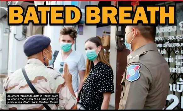  ?? Photo: Radio Thailand Phuket ?? An officer reminds tourists in Phuket Town to wear a face mask at all times while in public areas.