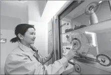  ?? PENG YUAN / XINHUA ?? A BOE employee performs a test on a smart fridge equipped with a display panel at a facility in Ordos, Inner Mongolia autonomous region.