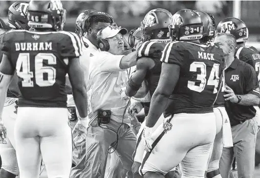  ?? Jeffrey McWhorter / Associated Press ?? A&amp;M coach Jimbo Fisher grabs linebacker Tyrel Dodson, obscured, by the facemask as he tries to calm his players after tempers flared on the field in the third quarter.