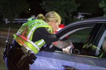  ??  ?? Officer Teresa Orr with the Jacksonvil­le Police Department speaks with a driver at a checkpoint May 20 in Jacksonvil­le, N.C. TINA BROOKS/THE JACKSONVIL­LE DAILY NEWS VIA AP, FILE