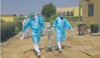  ?? SUNDAY ALAMBA/ASSOCIATED PRESS ?? Doctors ferry medical equipment for coronaviru­s patients April 30 at the Farcha provincial hospital in N’Djamena, Chad. While wealthier nations have stockpiled vaccines, many poorer countries, like Chad, have yet to receive any.