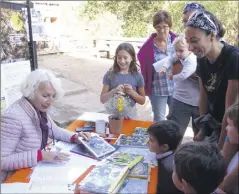  ?? (Photo P. Ma.) ?? Anne de Vespiland explique à une famille comment le venin, issu de piqûres d’abeilles, peut parfois guérir, comme l’attestent de nombreux témoignage­s.