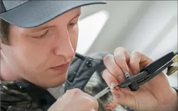  ?? Sydney Herdle ?? Garth Labar, a senior environmen­tal resource management student from Scranton, ties a wet ant fly during a fly-fishing class session at Penn State University.