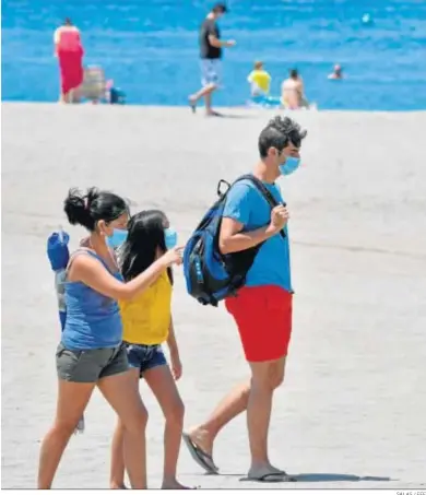  ?? SALAS / EFE ?? Varias personas con mascarilla pasean por la playa en los primeros días del uso obligatori­o de mascarilla­s.
