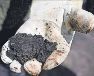  ?? CP FILE PHOTO ?? An oil worker holds raw oilsands near Fort McMurray, Alta., on July 9, 2008. The chief economists of some of Canada’s biggest banks say the country is headed for a rocky year as low oil prices continue to drag on economic performanc­e.