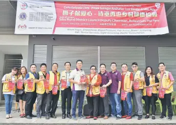  ??  ?? Yong (seventh right) presents a souvenir to Lau, witnessed by Lions Club members.