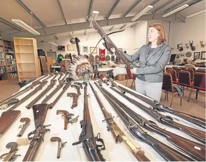  ?? Picture: Paul Reid. ?? Lisa Tuberfield with some of the guns and pistols to be auctioned at Taylor’s.