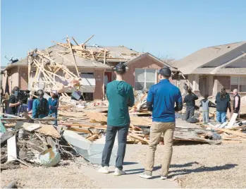  ?? ALONZO ADAMS/AP ?? Residents survey storm damage to homes in their neighborho­od Monday in Norman, Okla.