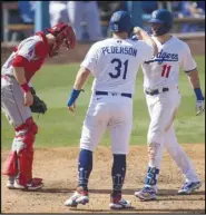  ?? Associated Press ?? DOUBLE SHOT — The Dodgers’ A.J. Pollock, right, celebrates his two-run home run with Joc Pederson, center, during the seventh inning against the Angels in Los Angeles on Sunday. Pollock hit two homers in the Dodgers’ 5-0 victory. The Dodgers swept the Angels in three games to end the season. They will begin the playoffs on Wednesday against the Brewers, while the Angels’ season comes to an end.