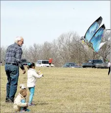  ?? FILE PHOTO ?? Michael Lorenz of Prairie Grove and his granddaugh­ters, Remy and Kennedy Stearmen, fly a large dragonfly kite during the 2017 Cane Hill Kite Festival.