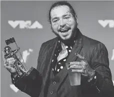  ?? EVAN AGOSTINI/THE ASSOCIATED PRESS ?? Post Malone poses with the award for song of the year for Rockstar in the press room at the MTV Video Music Awards in New York on Monday, the day before his eventful flight.