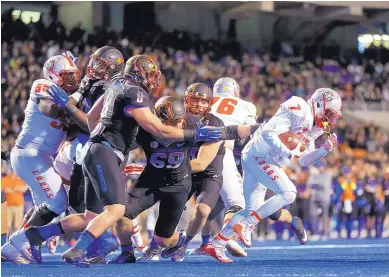  ?? OTTO KITSINGER/ASSOCIATED PRESS FILE ?? UNM running back Teriyon Gipson (7) runs away from Boise State defenders during the 2015 game. The Lobos were 30-point underdogs, but they came away with a 31-24 victory.