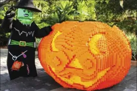  ?? LEGOLAND FLORIDA RESORT VIA AP ?? This 2015 image shows a giant pumpkin made from Legos at Legoland in Winter Haven, Fla., with a costumed greeter standing nearby. Both are back for this year’s fun.