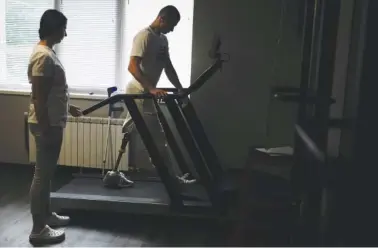  ?? AP PHOTO/NATACHA PISARENKO ?? Buffalo, the name he uses as a soldier, walks on a treadmill June 17 at a clinic in Kyiv, Ukraine. Buffalo was at the Azovstal plant, in an undergroun­d bunker. He was among those on the list for evacuation after being shredded by mortar rounds, losing his left leg above the knee.