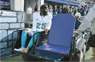  ?? TERRANCE WILLIAMS/AP ?? Dolphins cornerback Xavien Howard is carted off the field during the first half Sunday against the Ravens in Baltimore.