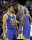  ?? TONY DEJAK — THE ASSOCIATED PRESS ?? Golden State’s Stephen Curry, left, and Kevin Durant talk in the final moments of Game 3 in Cleveland, Wednesday. Golden State won 118-113.