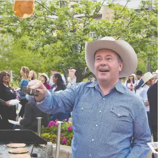  ?? GAVIN YOUNG ?? Alberta Premier Jason Kenney shows off his pancake flipping skills at the annual Premier's Stampede Breakfast in downtown Calgary Monday. Kenney and Energy Minister Sonya Savage are expected to meet with oilsands executives about the need for them to open their purses to create jobs and investment.