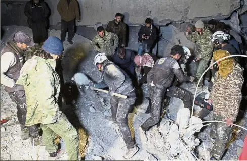 ??  ?? Digging for the
living: Volunteer rescue workers digging through the rubble after the air strike on the mosque in Aleppo. — AFP