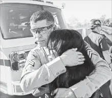  ?? MARCIO JOSE SANCHEZ THE ASSOCIATED PRESS ?? Los Angeles County Deputy Sheriff Armando Viera consoles an unidentifi­ed woman on a freeway overpass.