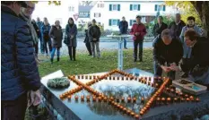  ?? Foto: Siegfried P. Rupprecht ?? Die Teilnehmer an der Gedenkstun­de legten als Symbol der Erinnerung Lichter am Mahnmal an der Thoma-linde nieder.