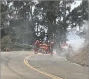  ??  ?? A special Cal Fire crew working on tearing down a eucalyptus tree and then putting the fire out, using chainsaws and axes while fighting the Grizzly Peak fire.