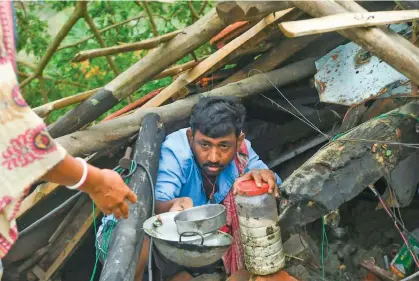  ?? Cyclone Amphan. Photo: AFP ?? Villagers in West Bengal salvage items from a house damaged by