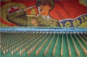  ??  ?? Legàmi Sopra, il look militaresc­o che caratteriz­za i Laibach sul palco. Sotto, una parata militare in Corea del Nord, Paese dove la band slovena ha potuto esibirsi due volte nel 2015 (foto Afp)