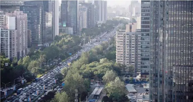  ?? — AFP ?? BEIJING: A general view shows a congested road in Beijing yesterday. Moody’s yesterday slashed China’s credit rating for the first time in almost three decades citing concerns about the country’s rising debt and slowing growth, but Beijing rejected the...